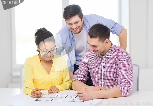 Image of three smiling architects working in office