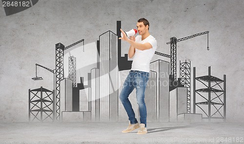 Image of handsome man with megaphone over concrete wall