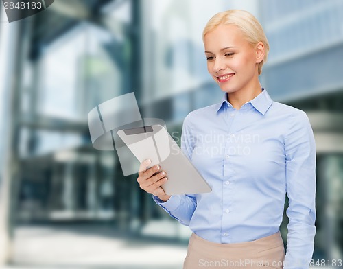Image of smiling woman looking at tablet pc computer