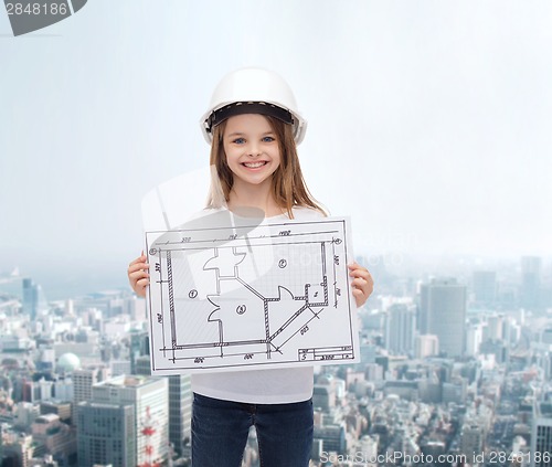 Image of smiling little girl in helmet showing blueprint