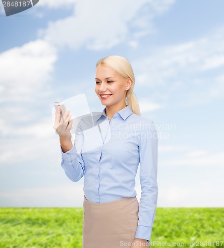 Image of young smiling businesswoman with smartphone