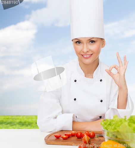 Image of female chef with vegetables showing ok sign