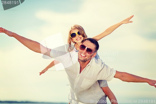 Image of happy father and child in sunglasses over blue sky