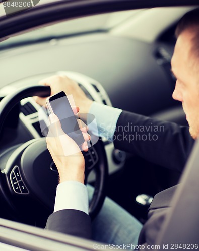 Image of man using phone while driving the car