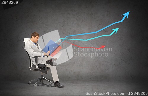 Image of handsome businessman with folders sitting on chair