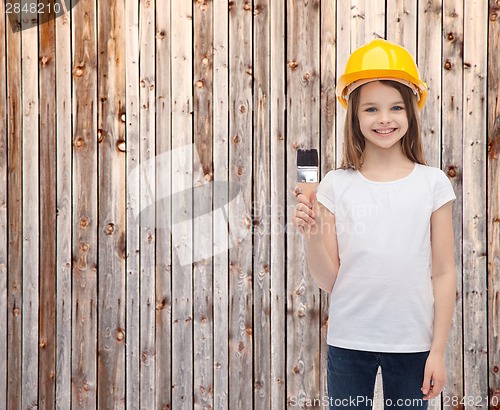 Image of smiling little girl in helmet with paint roller