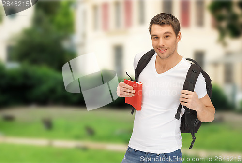 Image of travelling student with backpack and book