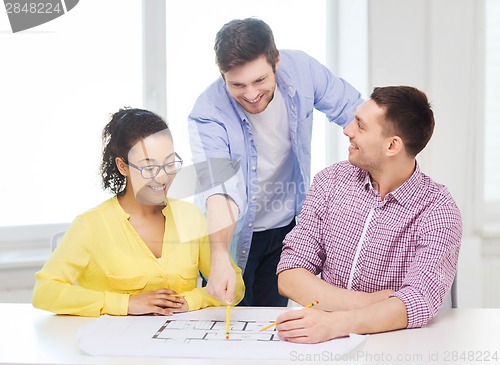 Image of three smiling architects working in office