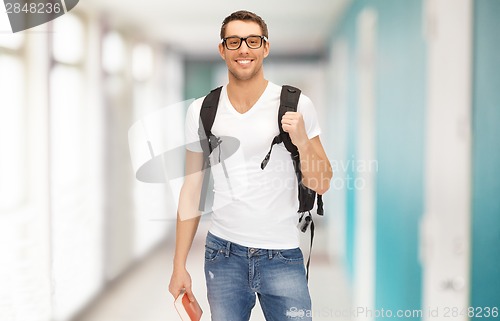 Image of smiling student with backpack and book