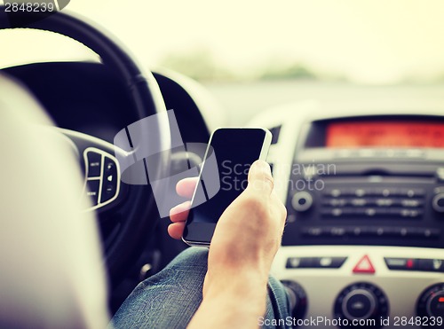 Image of man using phone while driving the car