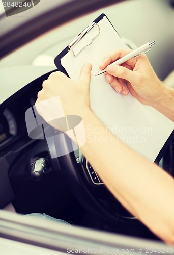 Image of man with car documents