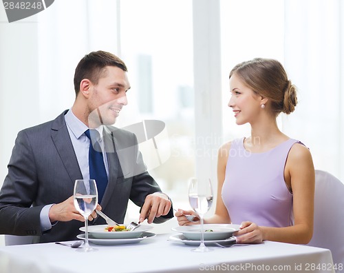 Image of smiling couple eating appetizers at restaurant