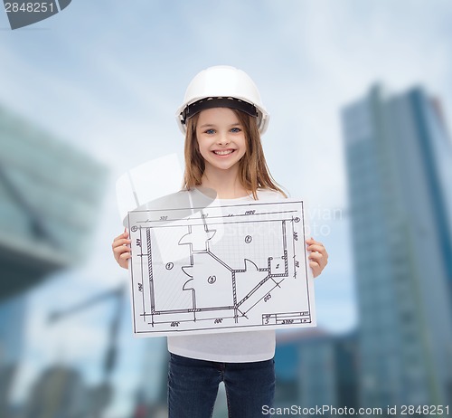 Image of smiling little girl in helmet showing blueprint