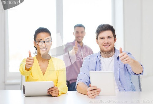 Image of smiling team with tablet pc computers at office