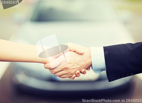 Image of customer and salesman shaking hands