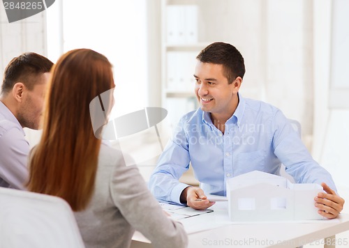 Image of couple looking at model of their house at office