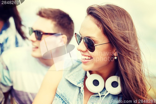 Image of smiling teenage girl outdoors with friends