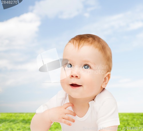 Image of smiling baby lying on floor and looking up