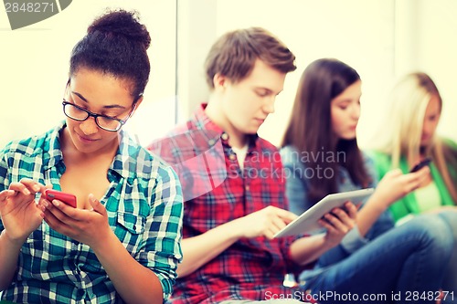 Image of students looking into devices at school