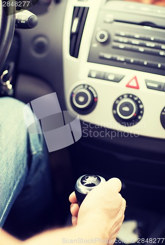 Image of man shifting the gear on car manual gearbox