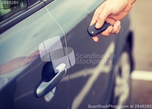 Image of man with car key outside