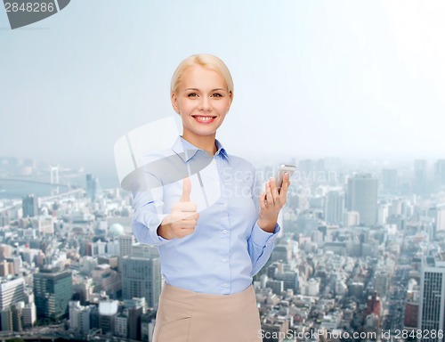 Image of young smiling businesswoman with smartphone