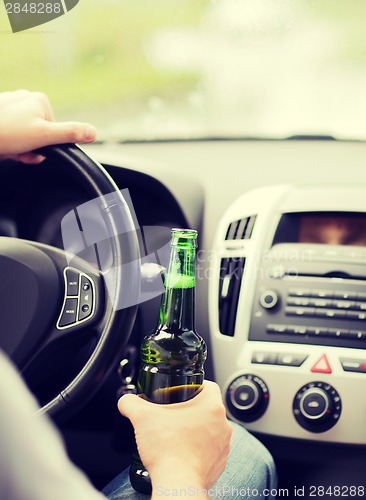 Image of man drinking alcohol while driving the car