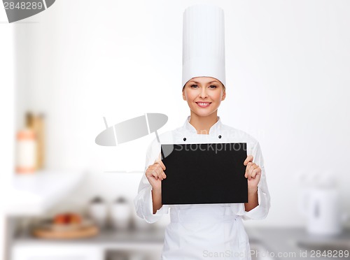 Image of smiling female chef with black blank paper