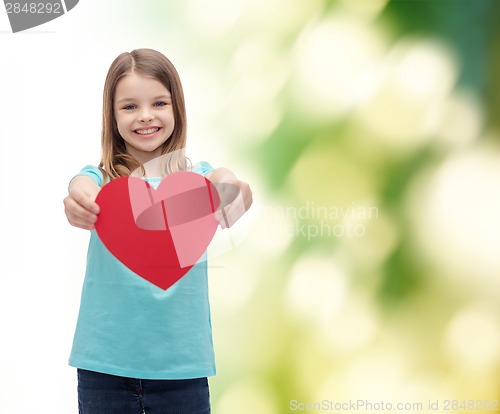 Image of smiling little girl giving red heart