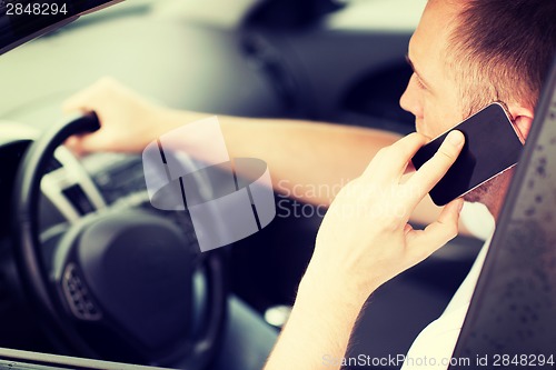 Image of man using phone while driving the car