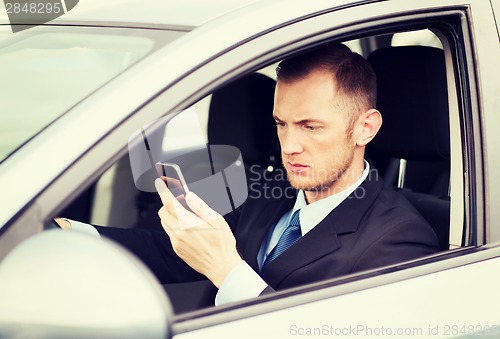 Image of man using phone while driving the car