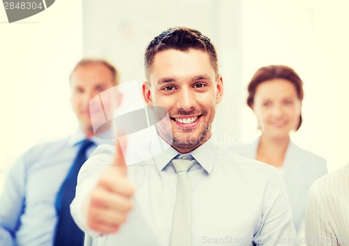 Image of businessman in office showign thumbs up