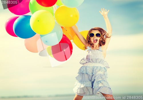 Image of happy jumping girl with colorful balloons