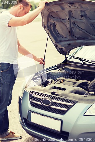 Image of man opening car bonnet