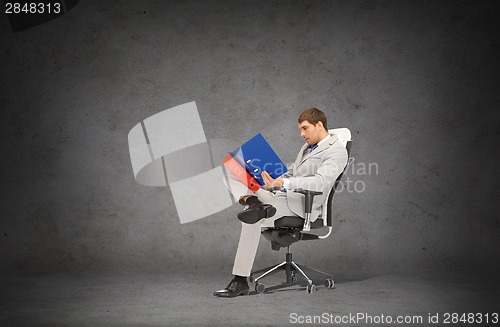Image of handsome businessman with folders sitting on chair