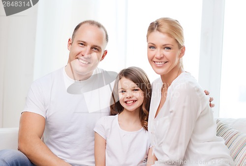 Image of smiling parents and little girl at home