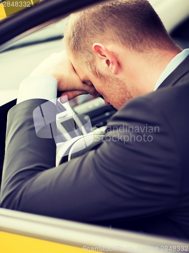 Image of tired businessman or taxi car driver