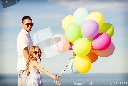 Image of happy father and daughter with colorful balloons