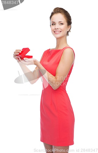 Image of smiling young woman in red dress with gift box