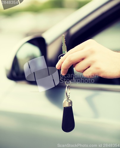 Image of man with car key outside