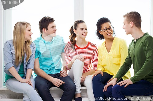 Image of five smiling teenagers having fun at home