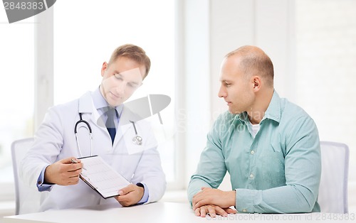 Image of doctor with clipboard and patient in hospital