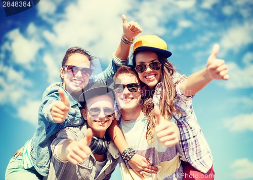 Image of smiling teenagers in sunglasses hanging outside