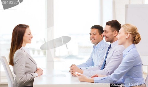 Image of smiling businesswoman at interview in office