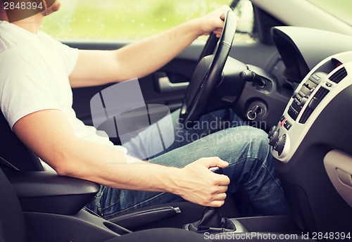 Image of man shifting the gear on car manual gearbox