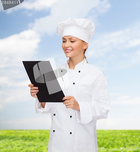 Image of smiling female chef with black blank paper