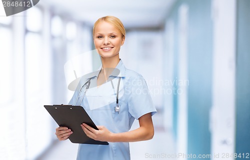 Image of smiling female doctor or nurse with clipboard