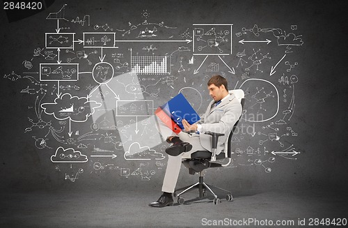 Image of handsome businessman with folders sitting on chair