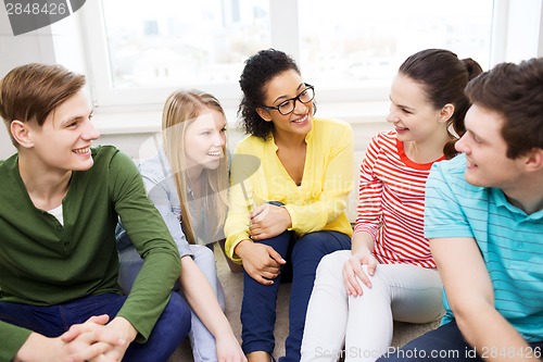 Image of five smiling teenagers having fun at home