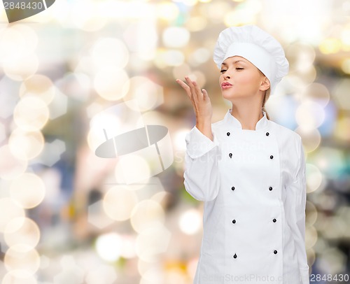 Image of smiling female chef showing delicious sign